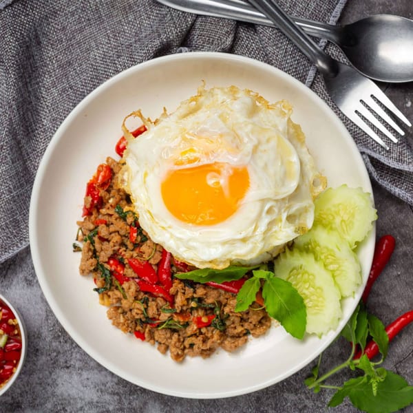 Pagan Restaurant's Burmese dish with minced meat, red chilies, basil, a fried egg, and cucumber slices.